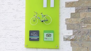 A green sign with the number 11, a bicycle illustration, and two logos for 'Das Bergische Wanderland' and 'tripadvisor'.