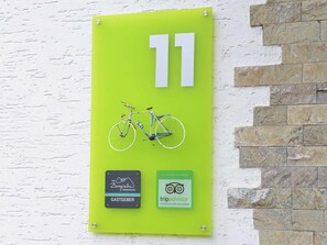 A green sign with the number 11, a bicycle illustration, and two logos for 'Das Bergische Wanderland' and 'tripadvisor'.