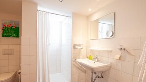 A modern bathroom with a shower, toilet, and sink.