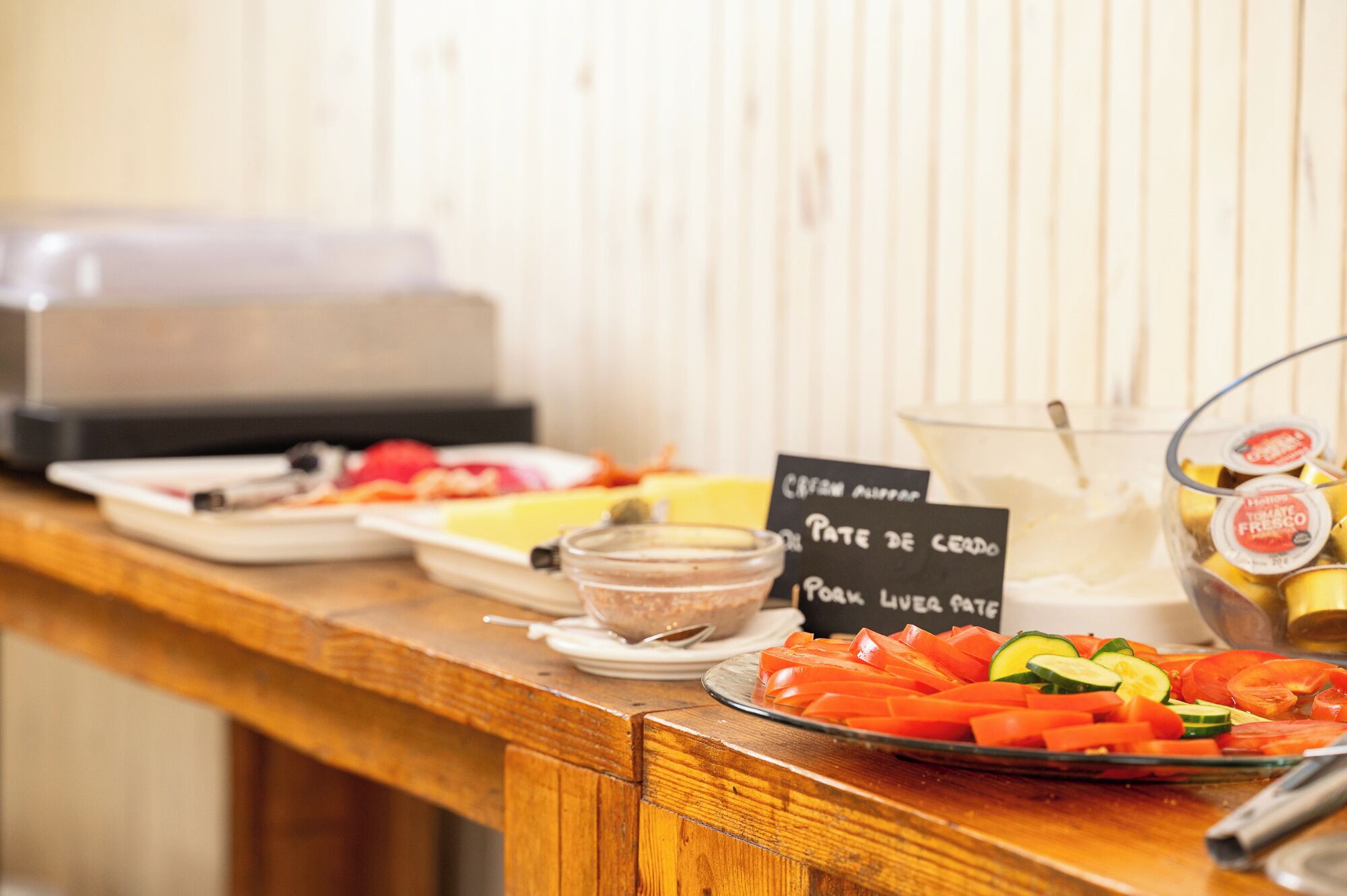 A buffet table with various food items and a sign indicating 'Pate de Cerdo' and 'Pork Livers'.