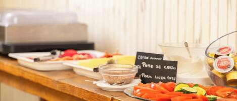 Mesa de buffet con diversos alimentos y un letrero que indica 'Pate de Cerdo' y 'Hígado de Cerdo'.