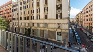 Un edificio de varios pisos con una hilera de comercios en la planta baja.