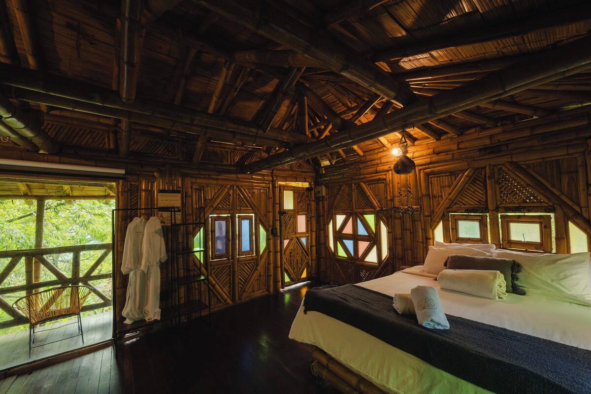 A wooden cabin with a bed, windows, and a chair.