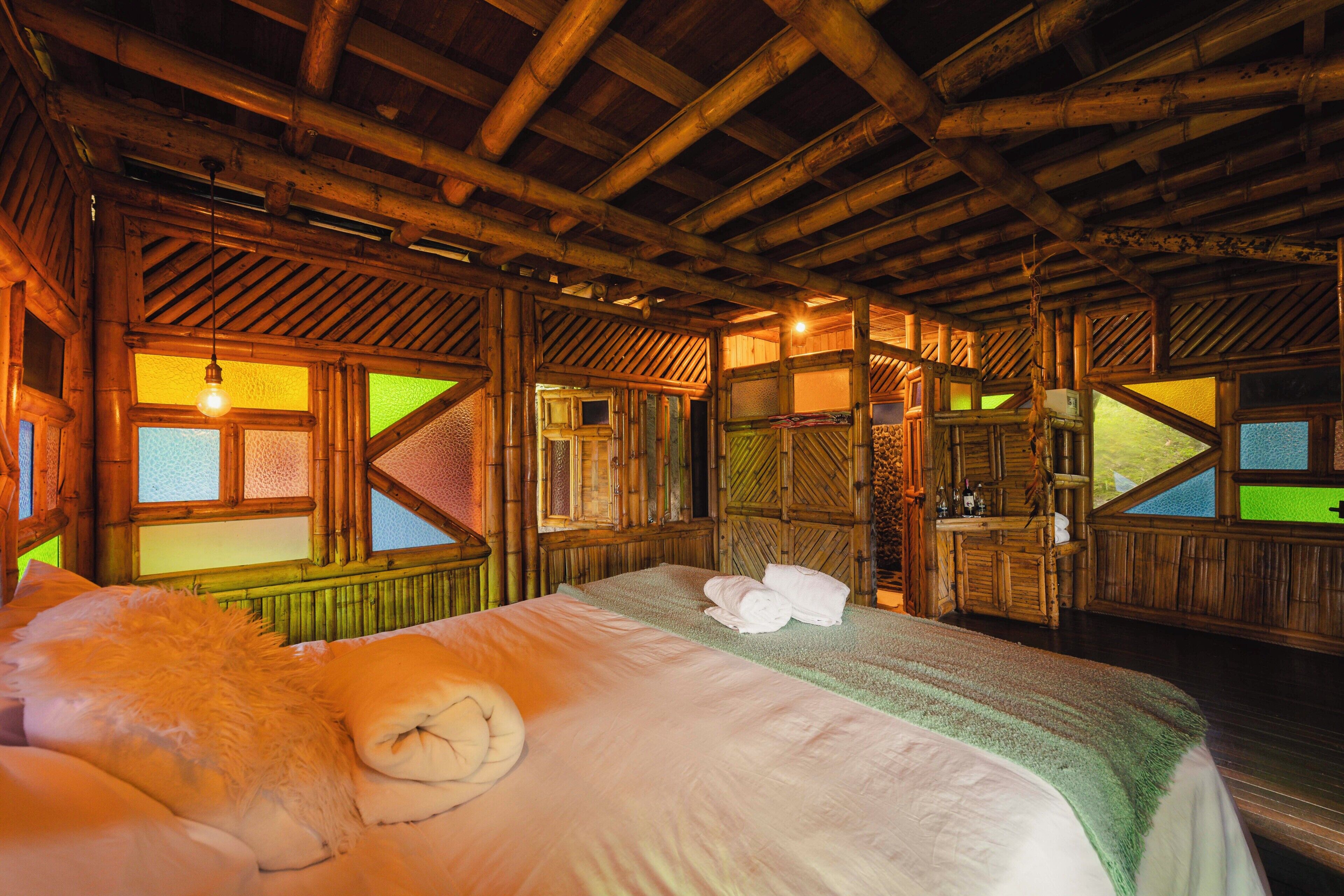 Una habitación con una cama, techo de madera y ventana con vistas.