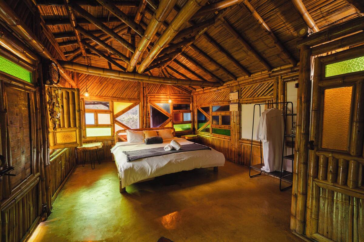 A room with a bed, a window, a door, and a shelf.