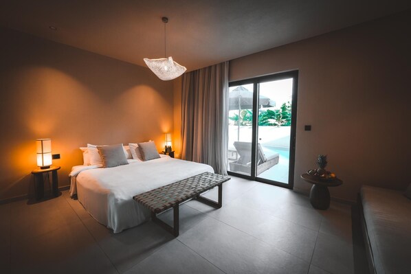 A hotel room with a bed, a bench, a table with fruit, and a view of an outdoor area. - Ananea More Meni Kos ex More Meni Beach (Kos)