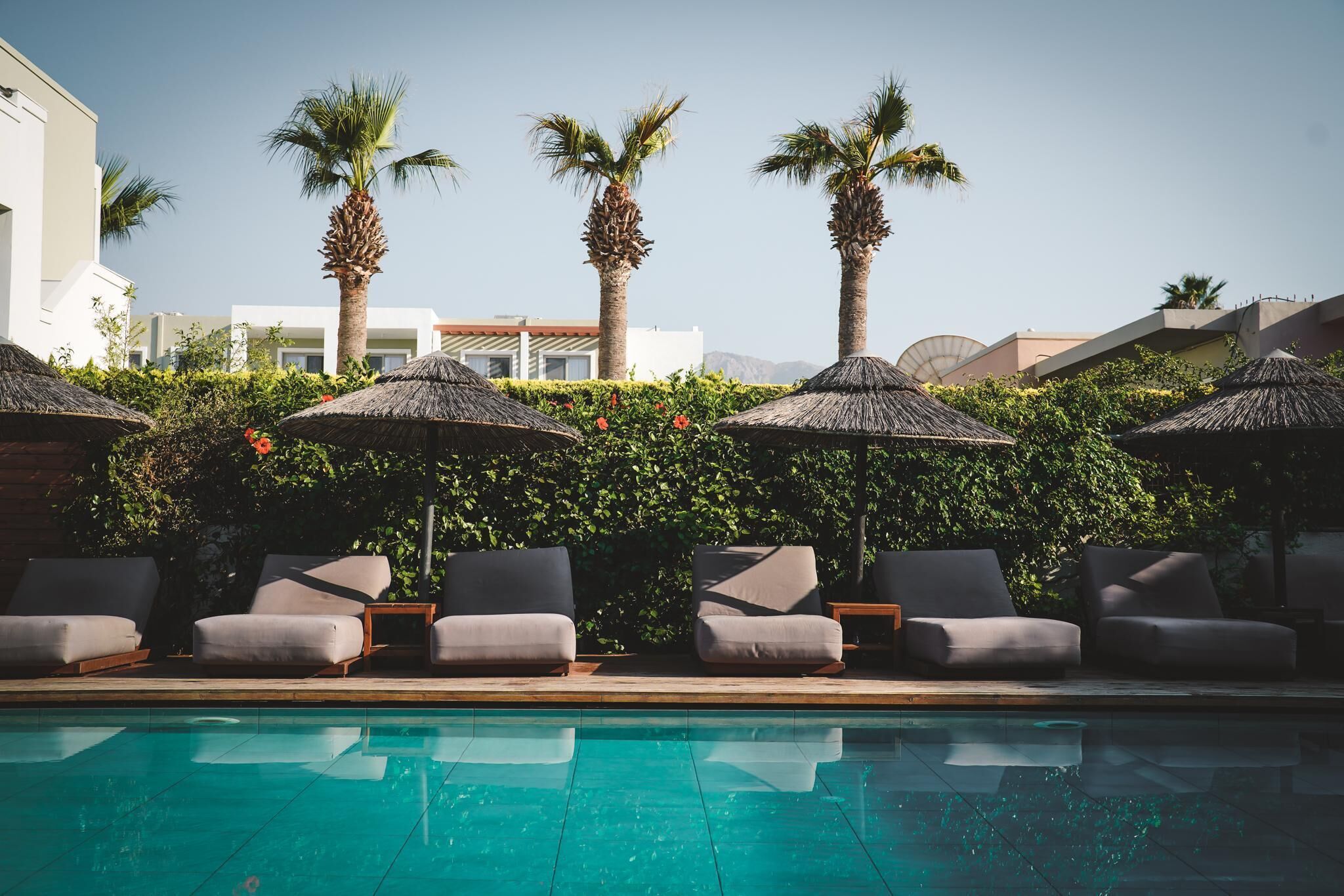 Una piscina al aire libre, sillones reclinables de piscina