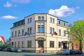 Et hotel i klassisk arkitekturstil, med en markant indgang og mange vinduer.