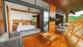 Un dormitorio moderno con una cama grande, un sofá, una mesa de centro y vistas al exterior.