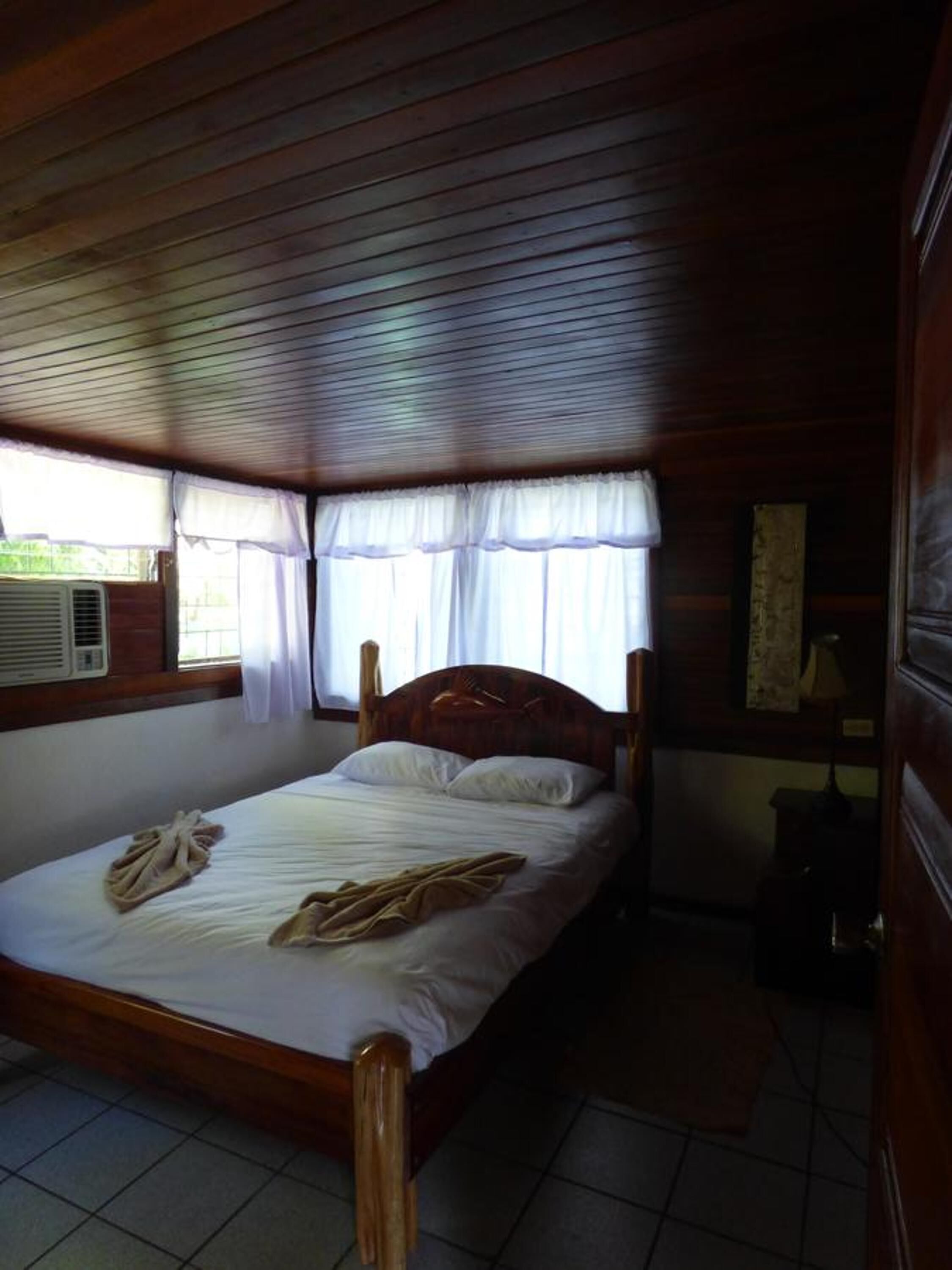 Ein Einzelbett mit Holz Kopfteil in einem Zimmer mit Holzwänden und Holzboden.