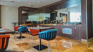 A modern kitchen with a central island, bar stools, and a dining area with chairs. - Xima Lima San Isidro (Lima)
