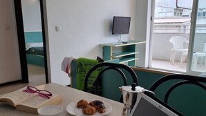 Une pièce avec une table mise pour le petit-déjeuner, un ordinateur portable, un livre et une tasse.
