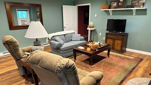 A living room with a sofa, armchair, coffee table, and television. - Creekside in the Smoky Mtns.
has a rejuvenating quality. Something we all need! (Otto)