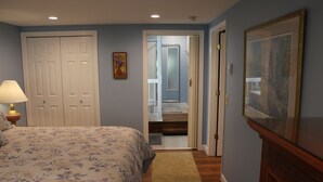 A bedroom with a bed, a nightstand, a lamp, a door, and a hallway leading to a bathroom. - Creekside in the Smoky Mtns.
has a rejuvenating quality. Something we all need! (Otto)