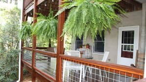 A wooden deck with a metal railing, potted plants, and a white door. - Creekside in the Smoky Mtns.
has a rejuvenating quality. Something we all need! (Otto)