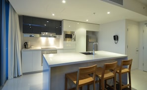 Enjoy cooking in this well-equipped kitchen with a large island, sink, and stainless steel oven.