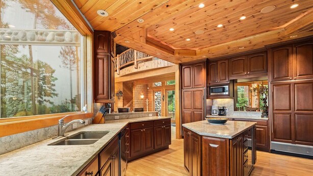 A spacious kitchen with wooden cabinets, a large island, and a built-in microwave.