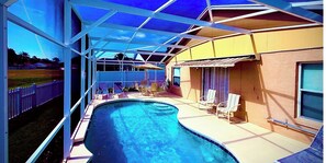 Ein Pool mit Liegestühlen und einer überdachten Terrasse.