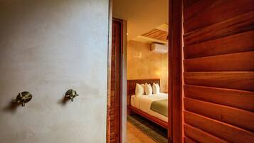 A bedroom with a wooden headboard, a bed with pillows, and a visible door.