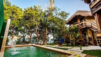 Una piscina al aire libre, sillones reclinables de piscina