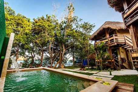 Una piscina al aire libre, sillones reclinables de piscina
