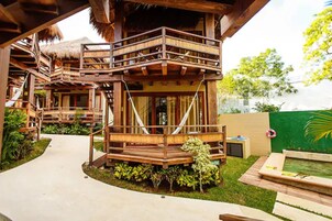 Una estructura de madera con balcón y una pequeña zona de piscina.