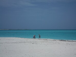Ein Strand mit zwei Personen, die am Ufer entlanggehen.