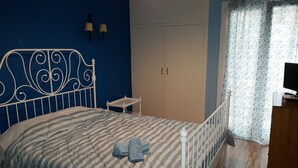 A bedroom with a bed, a nightstand, a wardrobe, and a television. - Luxury in the heart of the city (Thessaloniki)
