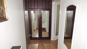 A hallway with wooden flooring, a white door, and a mirror on the wall. - Luxury in the heart of the city (Thessaloniki)