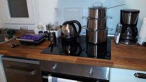 A kitchen with a stove, coffee maker, kettle, and various kitchen items. - Luxury in the heart of the city (Thessaloniki)