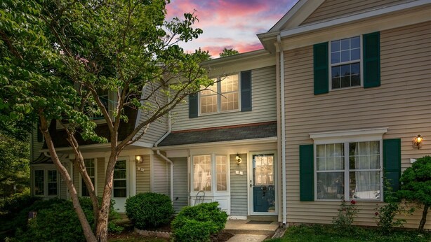 A two-story residential building with a front porch, a tree, and a well-maintained lawn. - BickelScape: Private Yard & Near DC (Sterling)