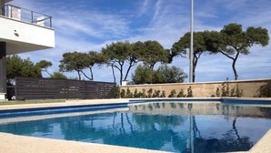 A swimming pool with a clear blue water surface, surrounded by a beige tiled deck. - Ground Floor With Stunning Sea Views And Private Terrace, Shared Pool (Pollença)