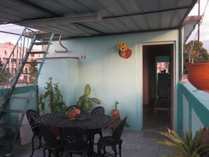 Relax in this serene outdoor seating area, surrounded by lush plants and a view of the surrounding buildings.
