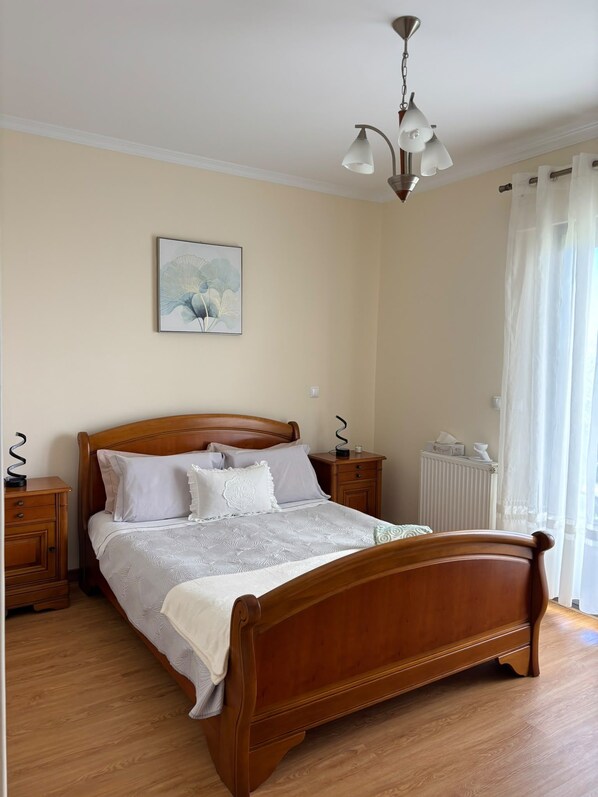 A bedroom with a wooden bed, two bedside tables, a radiator, and a ceiling light fixture. - Villa - Santa Cruz (Santa Cruz)