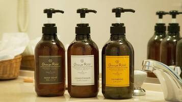 Three bottles of Orange Rose products on a bathroom counter.