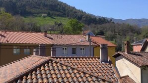 Ein Wohngebiet mit Terrakotta-Dachziegeln, ein Hügel im Hintergrund und ein klarer Himmel.