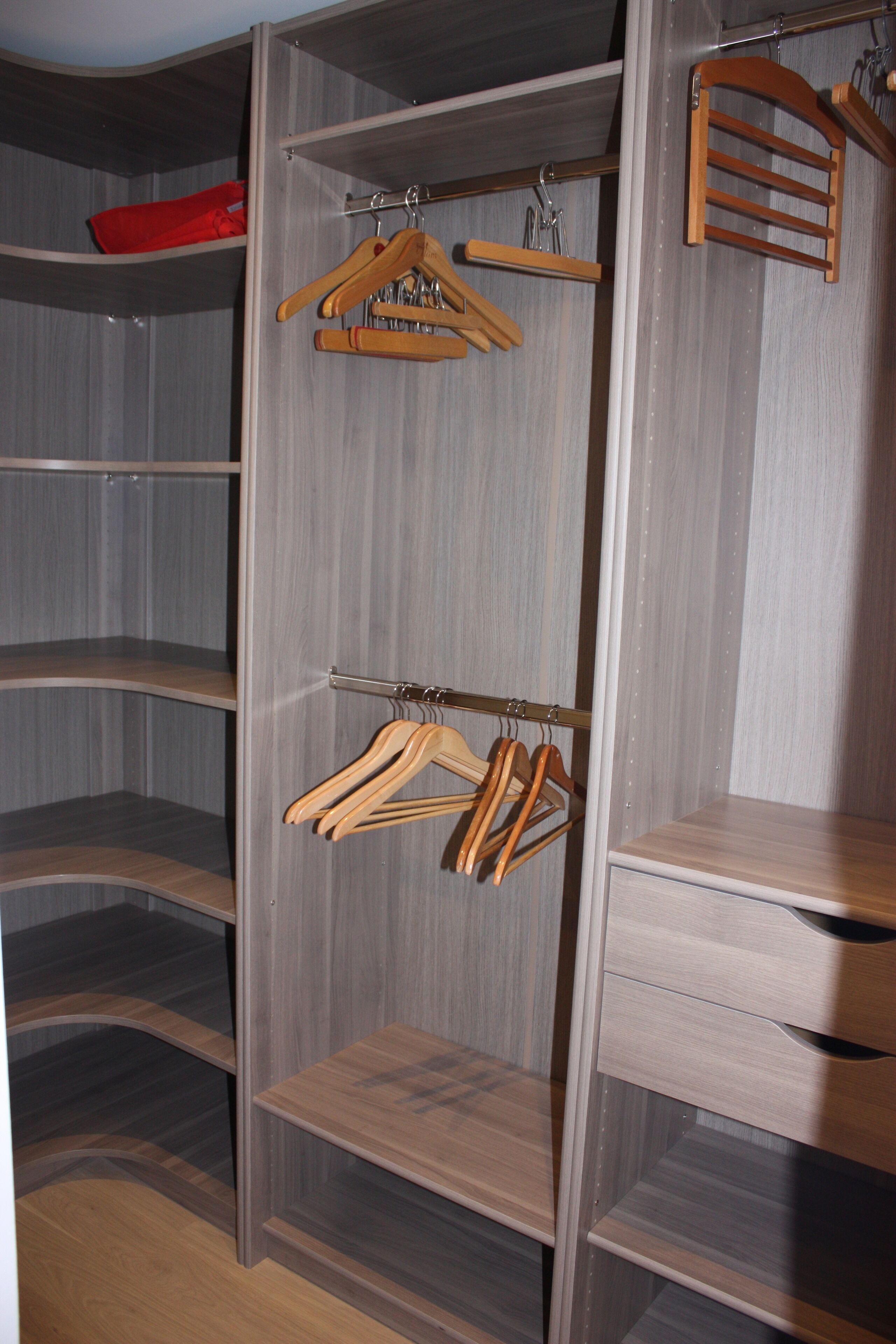 A walk-in closet with wooden hangers and shelves.