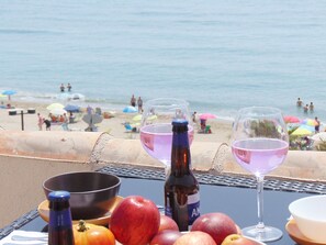 A table with a bottle, two glasses, and fruits. - LUXURY APARTMENT IN THE FIRST LINE OF IDEAL BEACH FOR FAMILIES. (Fuengirola)