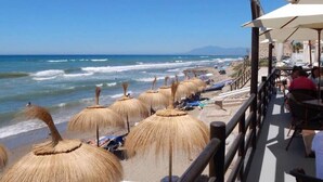 A beachside restaurant with thatched umbrellas and outdoor seating overlooking the ocean. - Sun Lover`s Paradise.  Private rooftop seaview terrace, amazing romantic holiday (Marbella)