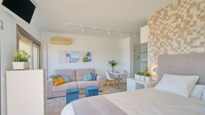 A modern bedroom with a bed, a desk, and a sofa. - Sun Lover`s Paradise.  Private rooftop seaview terrace, amazing romantic holiday (Marbella)