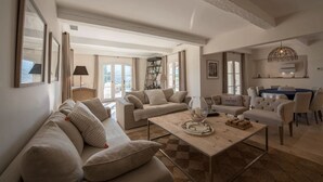 Ein geräumiges Wohnzimmer mit einer großen Couch, einem Couchtisch und einem Essbereich mit Tisch und Stühlen.