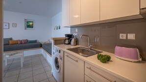 Una cocina compacta con lavadora, tostadora y lavaplatos.