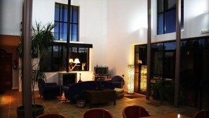 Un salon moderne doté d’une cheminée, d’un coin salon et de grandes fenêtres.