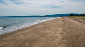 Una playa con arena y olas suaves.