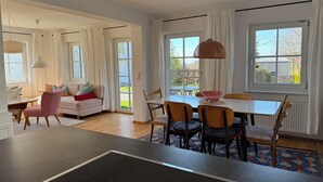 A modern kitchen with a dining area, large windows, and a view of the outdoors. - Vacation apartment at Obstgut Willmann, quiet location with a view of Lake Constance (Kressbronn)