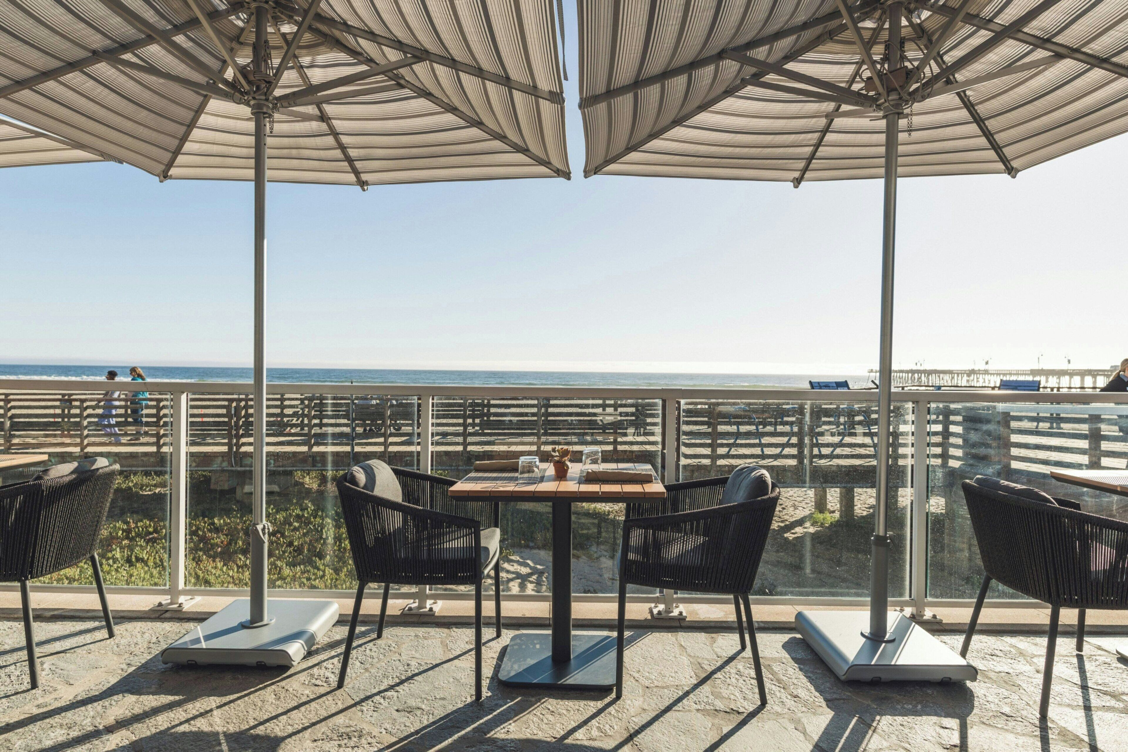 Une terrasse avec des sièges extérieurs, une table et une vue sur l’océan.