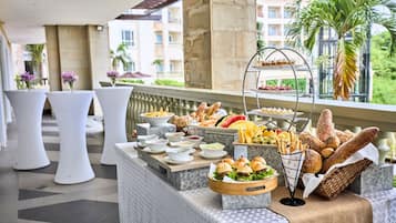 A buffet setup with various food items and a fruit display.