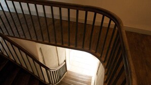 A wooden staircase with a metal railing.