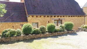 A stone building with a sloped roof and a gravel driveway. - *** Perigord cottage with pool (Archignac)