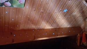 A cozy attic bedroom with a wooden sloped ceiling, a built-in bench, and a star-shaped light fixture. - Spring nature and sport in 'fleur de sologne' (Souvigny-En-Sologne)